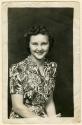 Seated woman smiling in floral dress