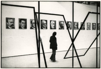 Visitor to the Pompidou Center looking at installation - a portrait exhibtion in the industrial design center, Paris, France