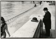 Standing man drinking coffee by the side of the river, Paris, France